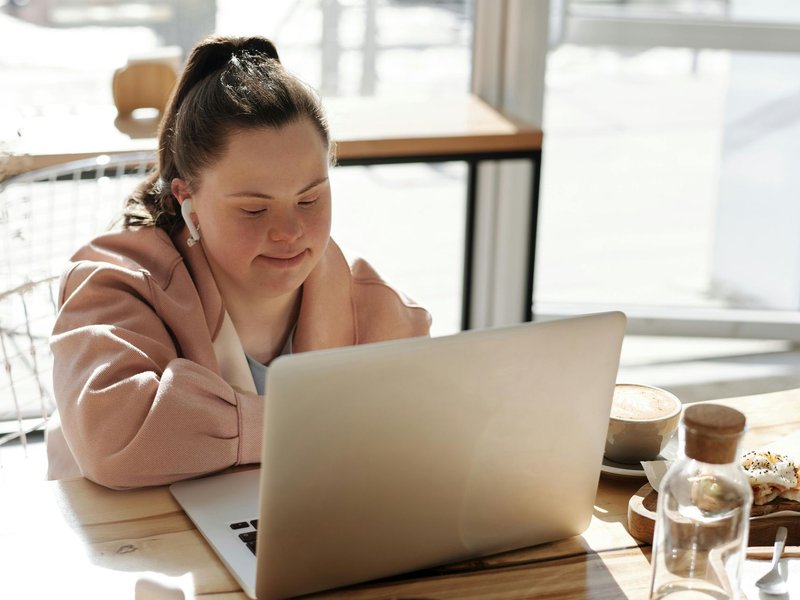 A young woman working independently on her laptop at a cafe