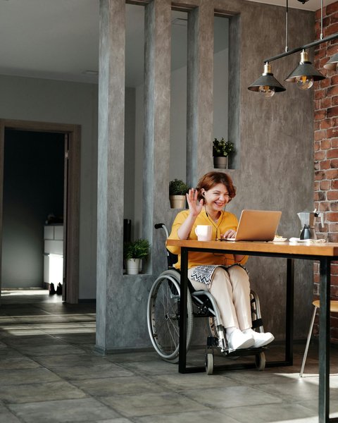 A woman using a wheelchair working from her home laptop